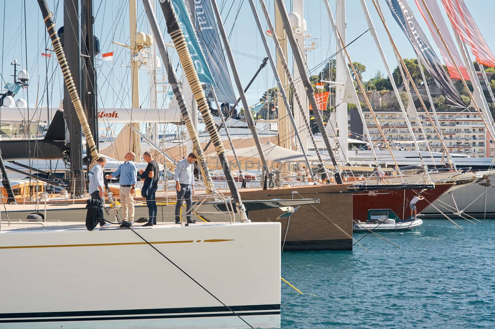 Monaco, Monte Carlo, 28 September 2022 - Invited wealthy clients inspect megayachts at the largest fair exhibition in the world yacht show MYS, port Hercules, yacht brokers, sunny weather. High quality photo