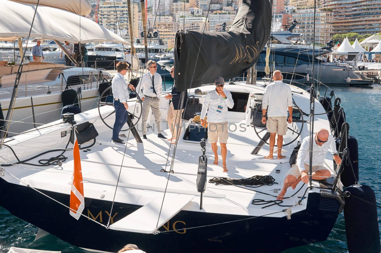 Monaco, Monte Carlo, 28 September 2022 - Invited wealthy clients inspect megayachts at the largest fair exhibition in the world yacht show MYS, port Hercules, yacht brokers, sunny weather. High quality photo