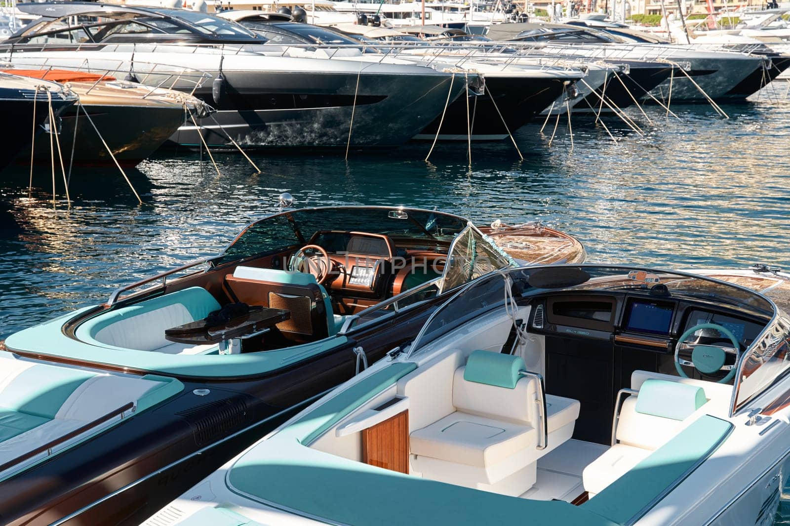 Monaco, Monte Carlo, 28 September 2022 - Riva boats in a row and a lot of luxury mega yachts at the famous motorboat exhibition in the principality, yacht brokers and clients. High quality photo