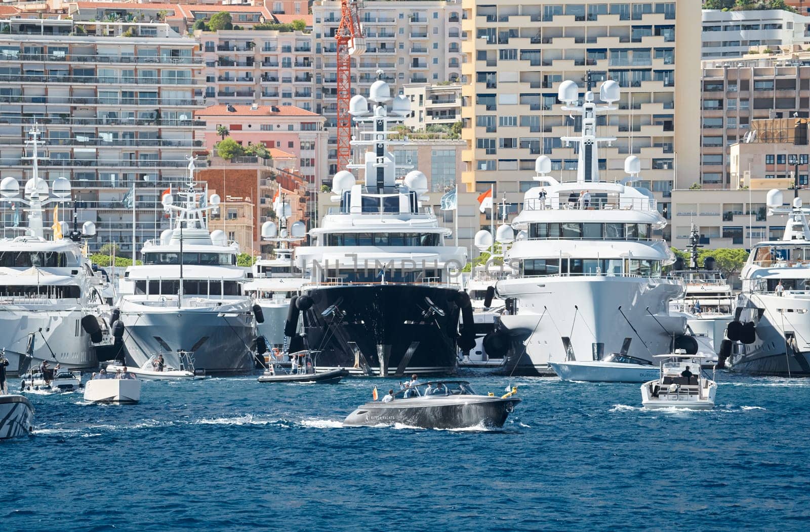 Monaco, Monte Carlo, 28 September 2022 - a motor boat with guests of yacht brokers departs from the shore in the largest fair exhibition in the world yacht show MYS, port Hercules, rich clients, sunny. High quality photo