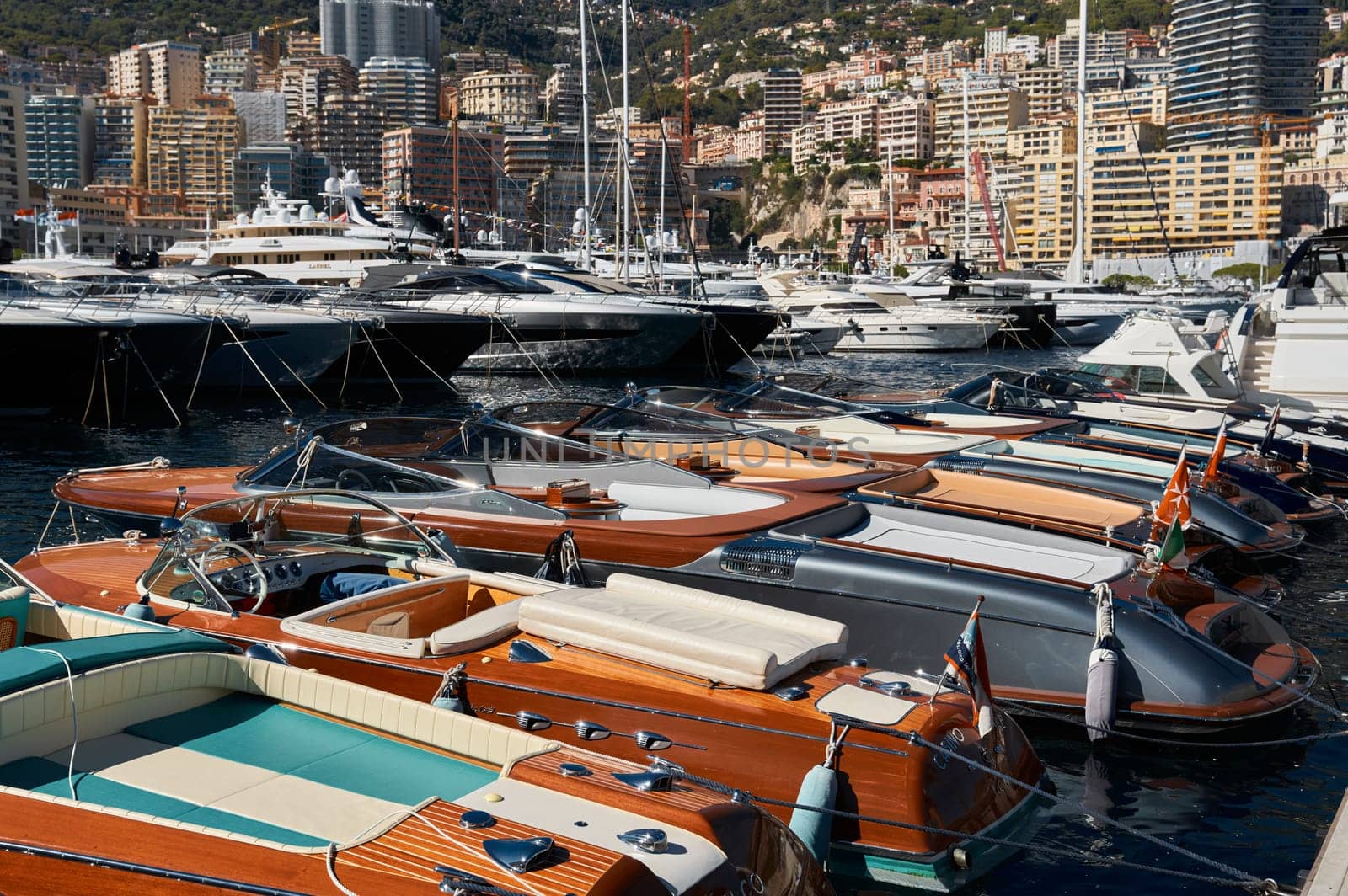 Monaco, Monte Carlo, 28 September 2022 - Riva boats in a row and a lot of luxury mega yachts at the famous motorboat exhibition in the principality, yacht brokers and clients. High quality photo