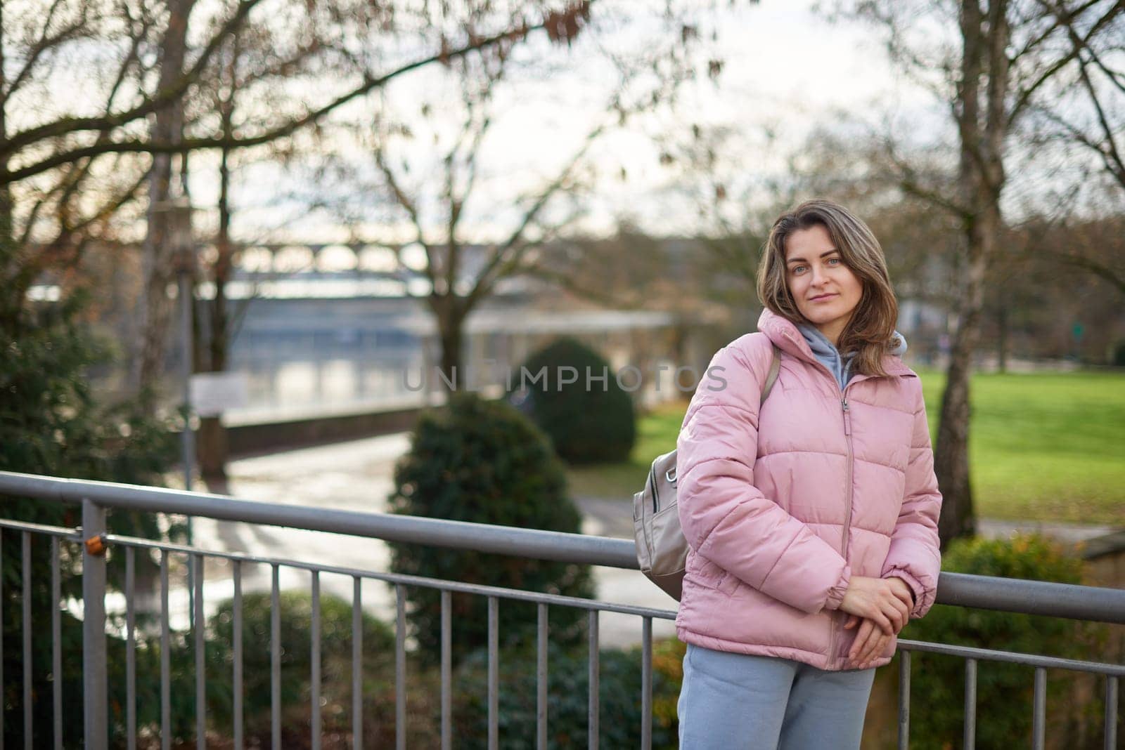 Young beautiful pretty tourist girl in warm hat and coat with backpack walking at cold autumn in Europe city enjoying her travel in Bietigheim-Bissingen, Deutschland. Outdoor portrait of young tourist woman enjoying sightseeing by Andrii_Ko