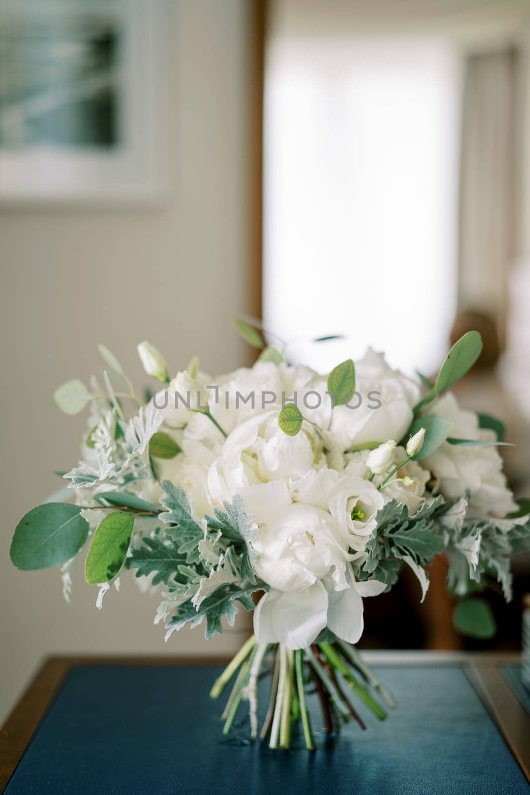 Bride bouquet stands on the table in the room. High quality photo
