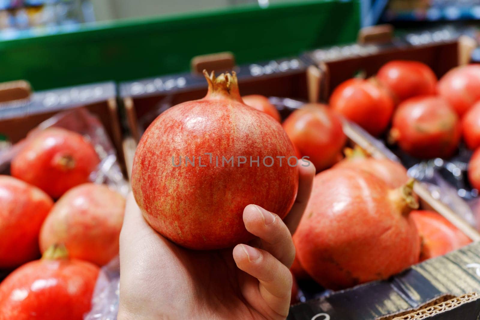 Pomegranate fruit on the shelves of a grocery hypermarket. Selective focus. Buying fruit