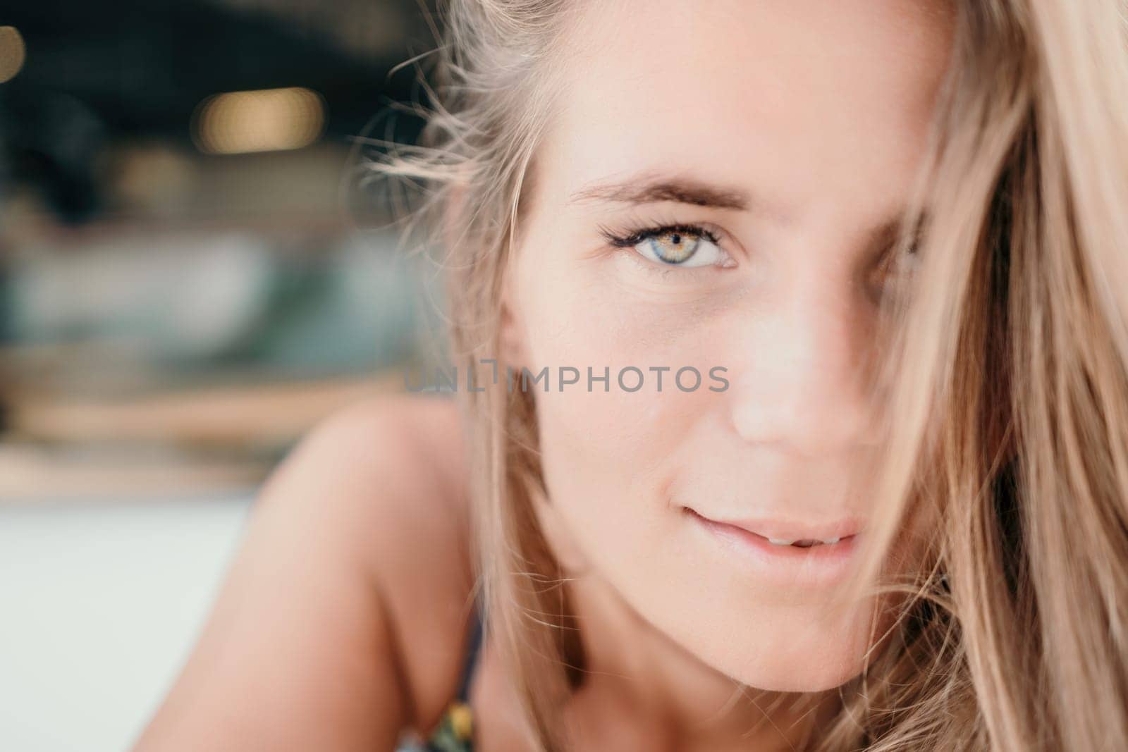 Happy woman portrait in cafe. Boho chic fashion style. Outdoor photo of young happy woman with long hair, sunny weather outdoors sitting in modern cafe. by panophotograph