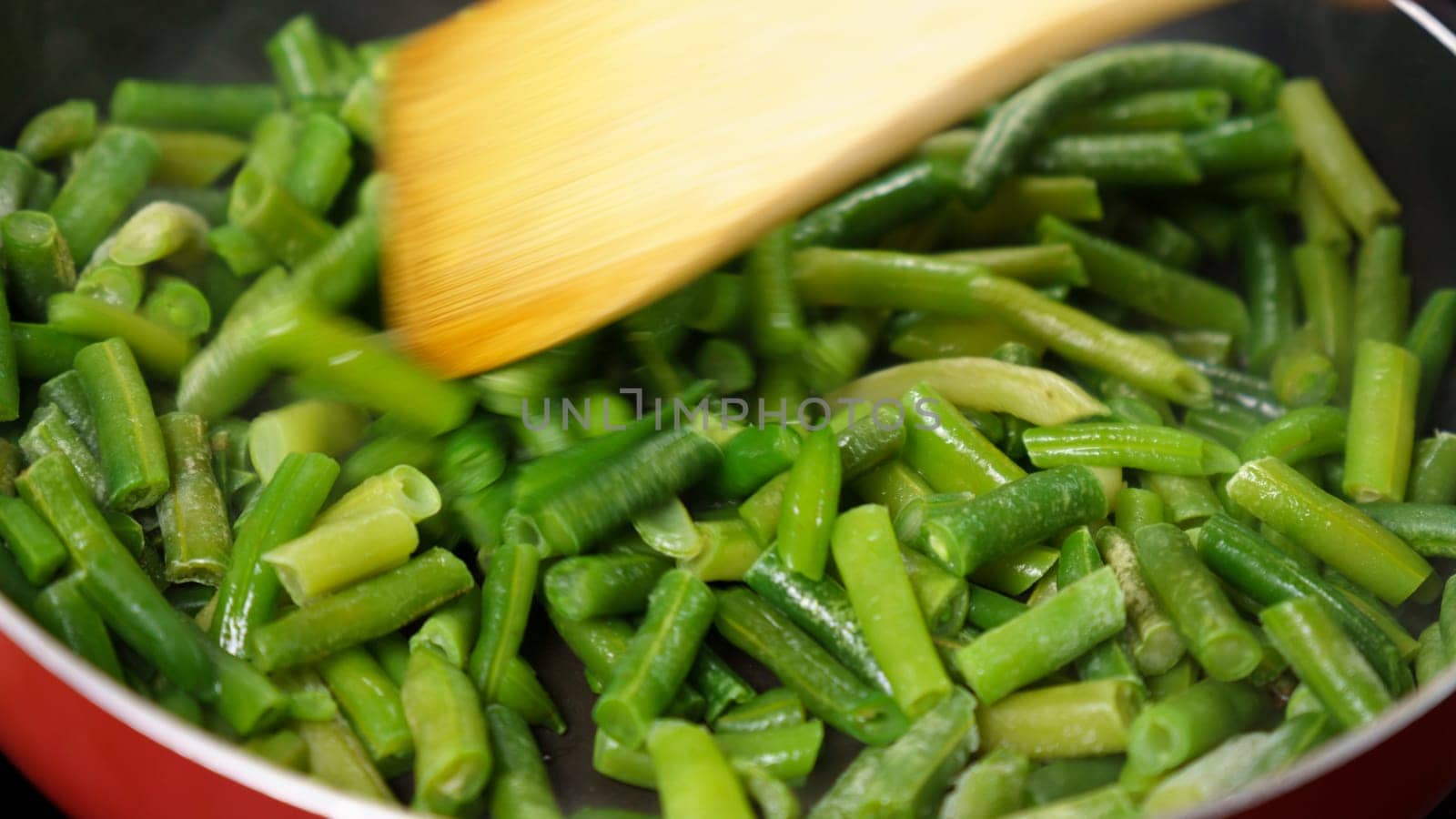 Green beans are being cooked in a pan, close up. Selective focus