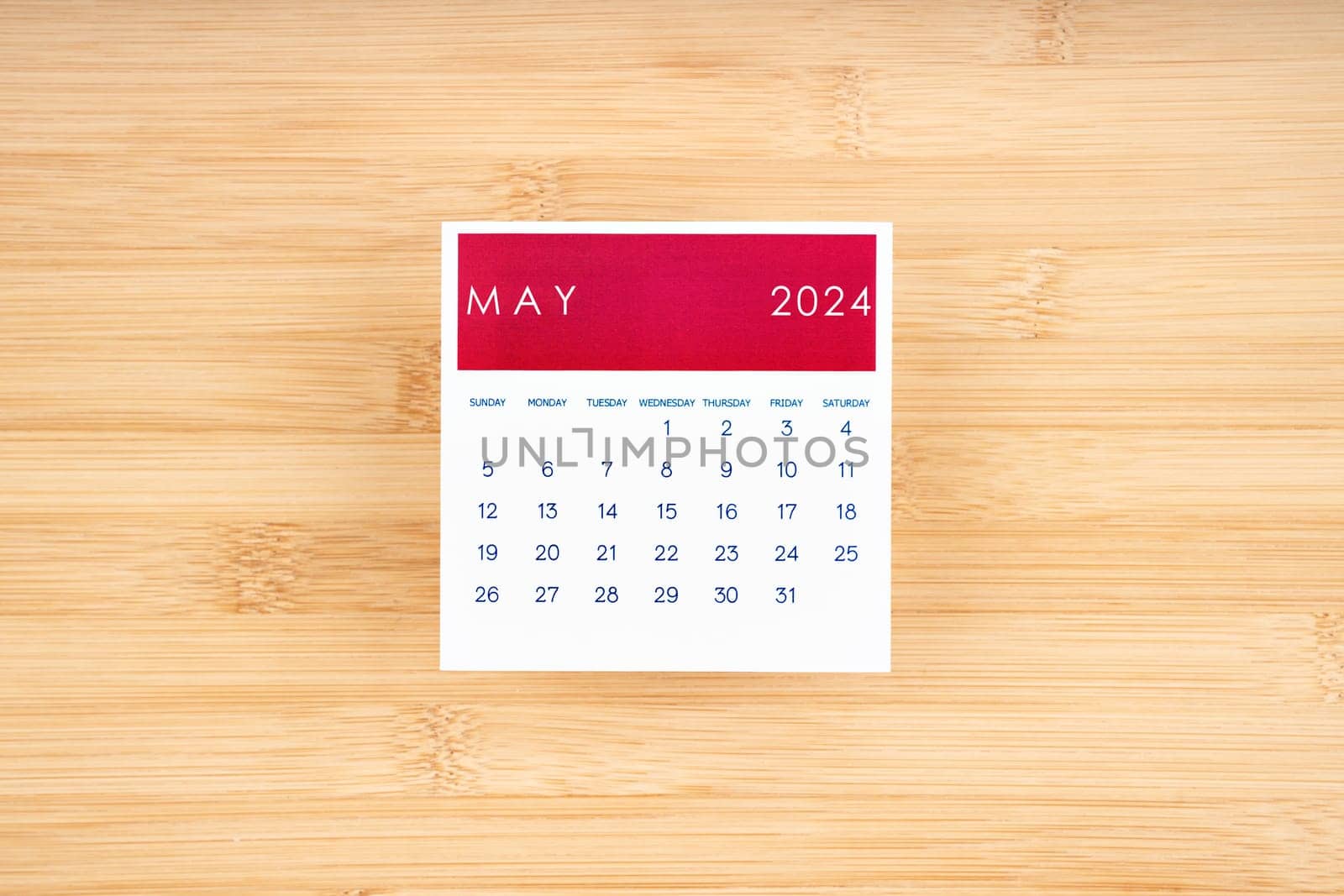 May 2024 calendar page on wooden background with empty space.