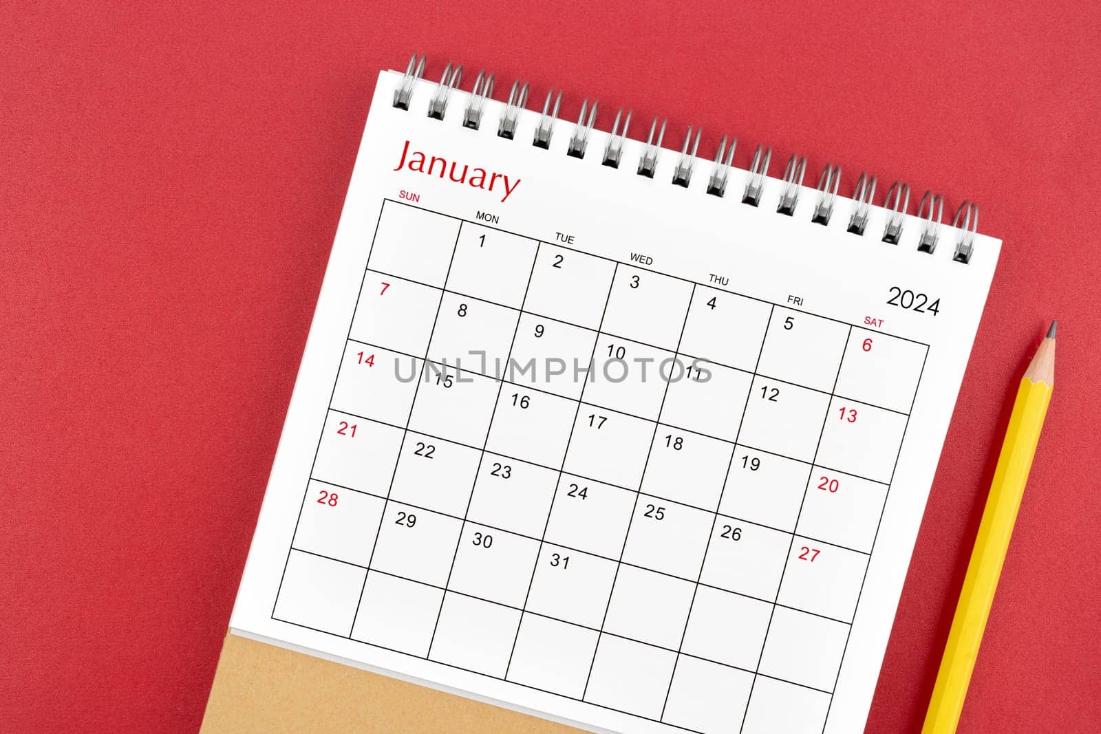 January 2024 desk calendar and pencil on red background. by Gamjai