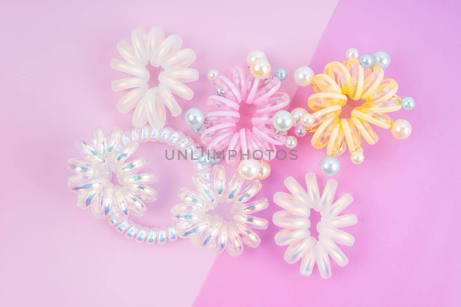 Colorful plastic hair elastics set on beautiful background.