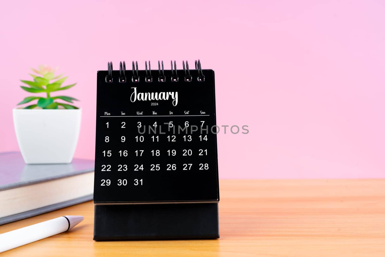 January Mini desk calendar for 2024 year on worktable with pink color background.