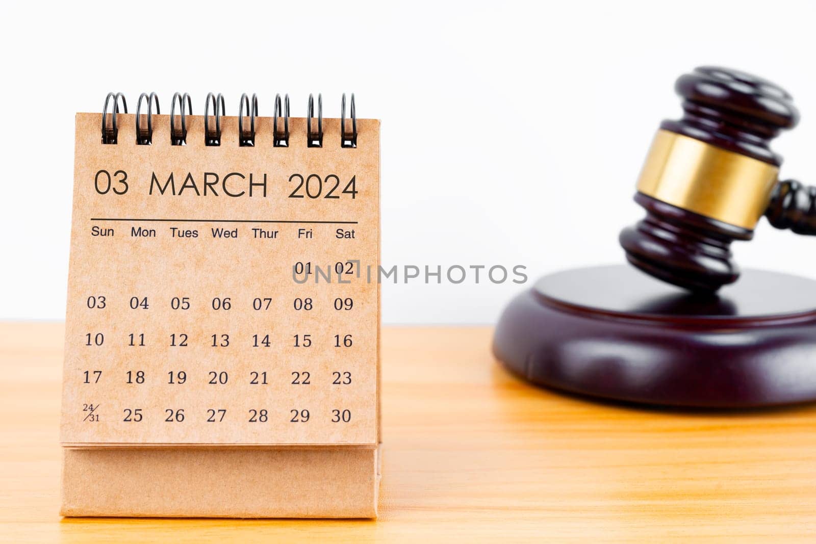 Desk calendar for March 2024 and judge's gavel on the worktable.