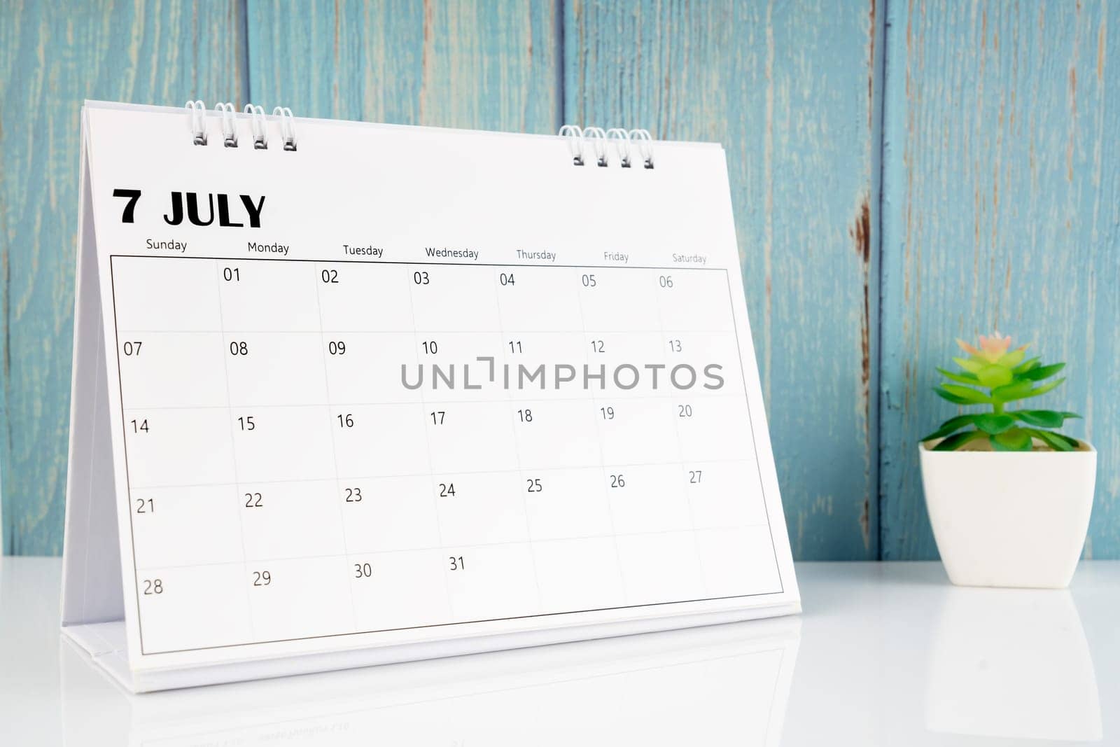 June 2024 calendar on the white table with blue wooden background.