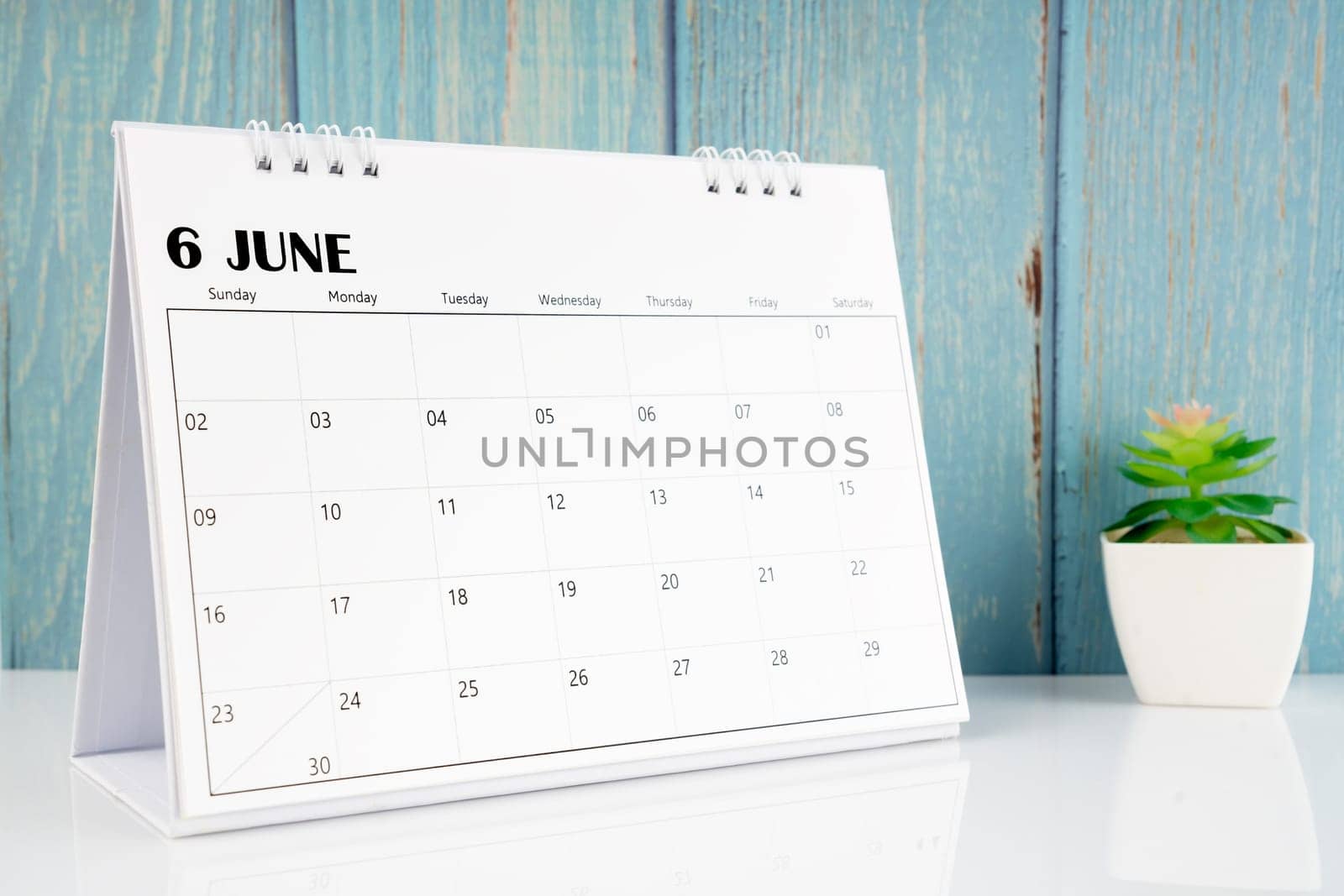 July 2024 calendar on the white table with blue wooden background.