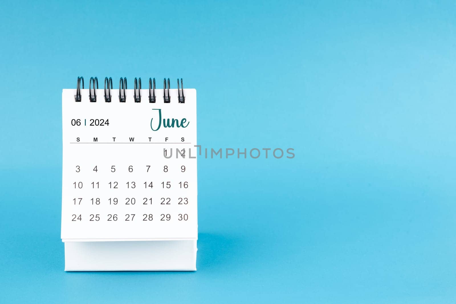 June 2024 mini desk calendar on blue color background. by Gamjai