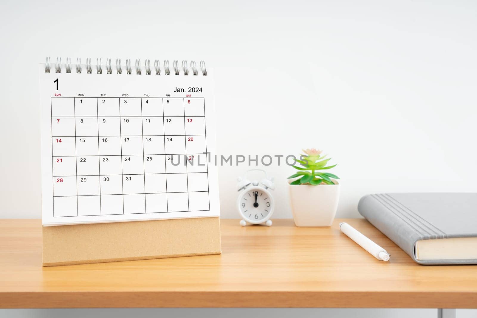 January 2024, Monthly desk calendar for 2024 year on wooden table with diary.
