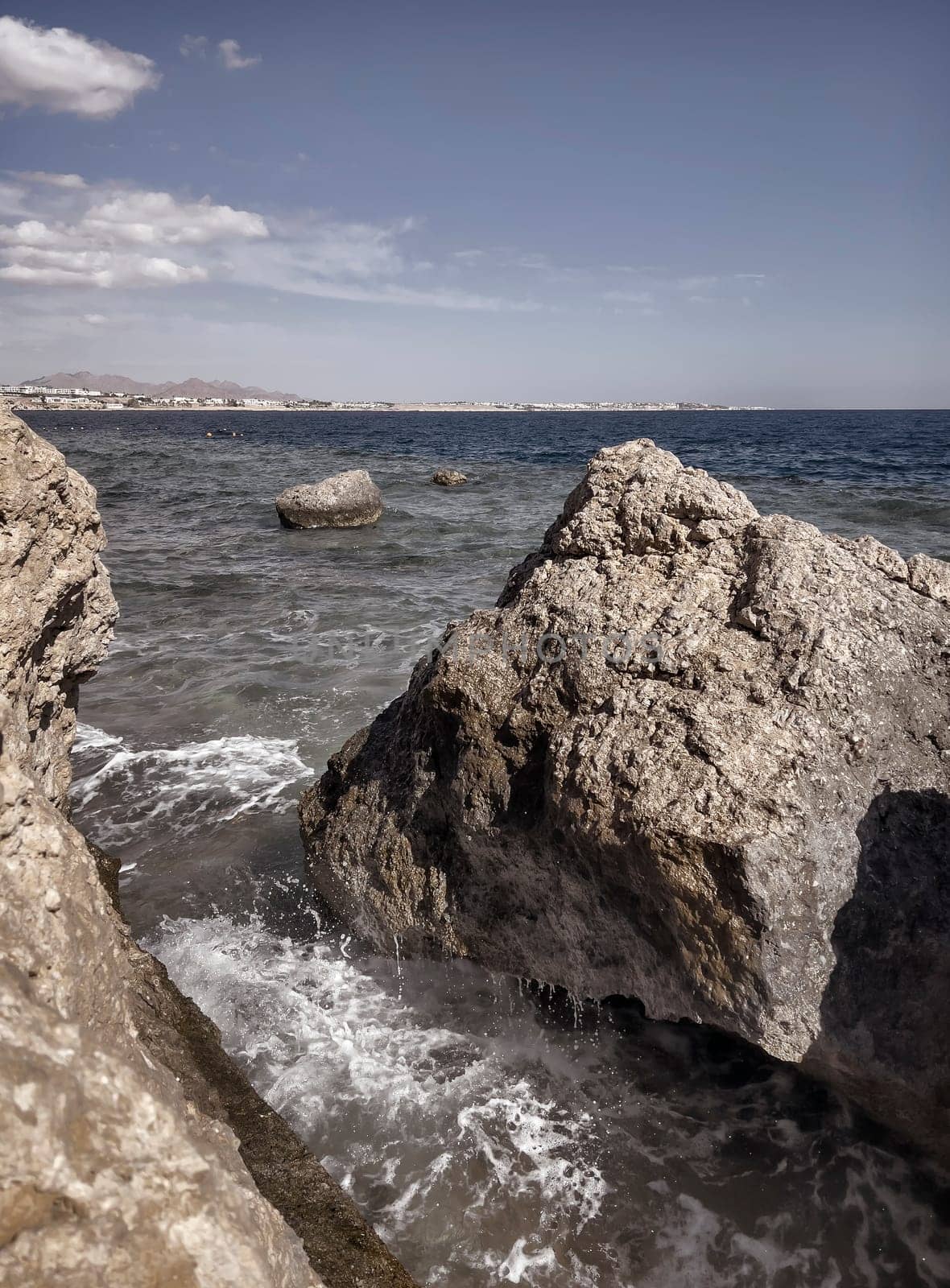 The waves of the sea surf break on a rocky cliff by georgina198