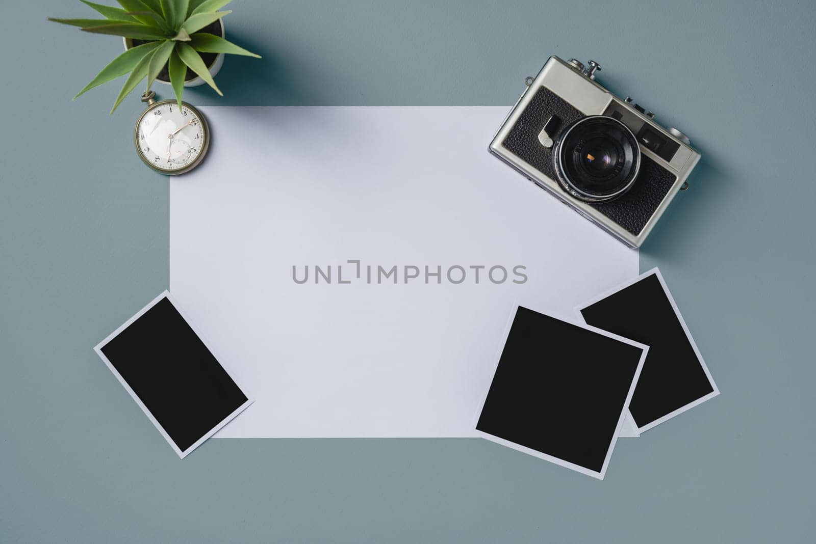 Vintage photo camera and empty photo frames on blue background. Travel moment concept by Sonat