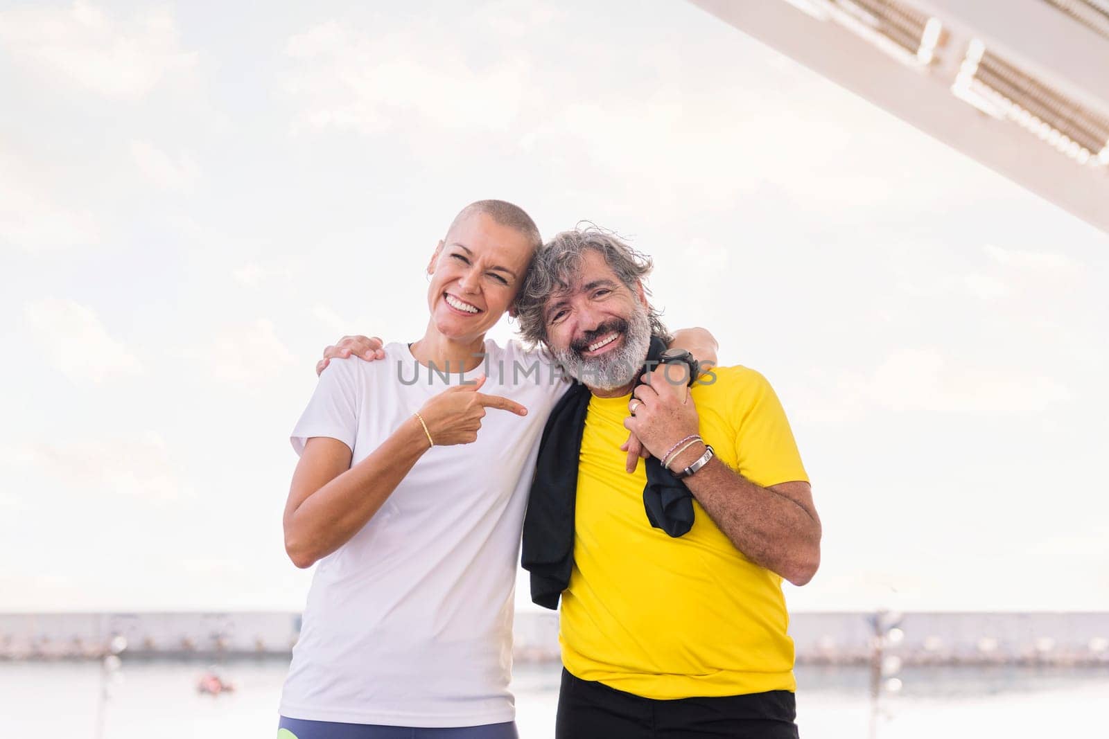 portrait of a sports senior man with young woman laughing happy looking at camera, concept of active and healthy lifestyle, copy space for text