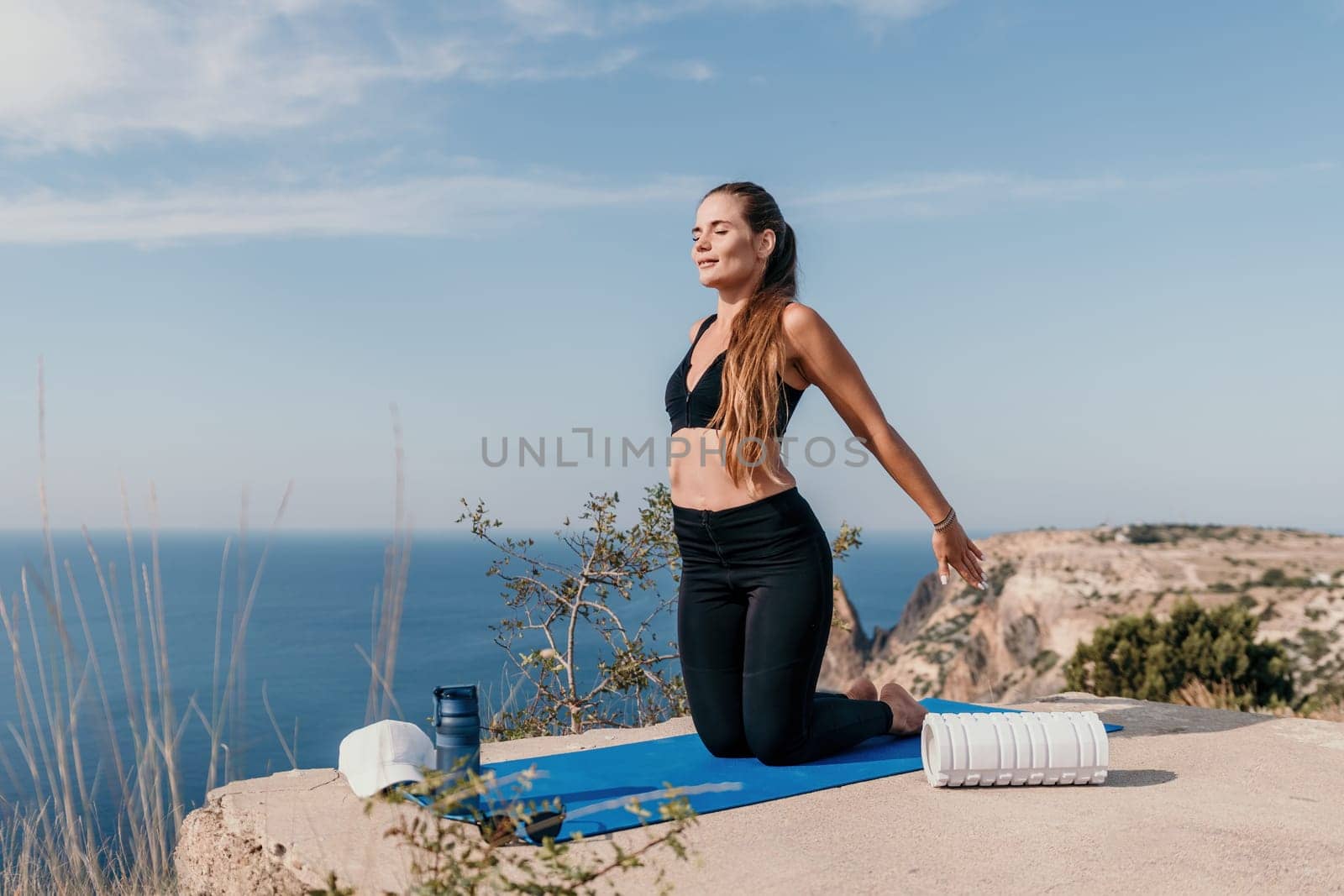 Fitness woman sea. Outdoor workout on yoga mat roller in park near to ocean beach. Female fitness pilates yoga routine concept. Healthy lifestyle. Happy fit woman exercising with rubber band in park. by panophotograph