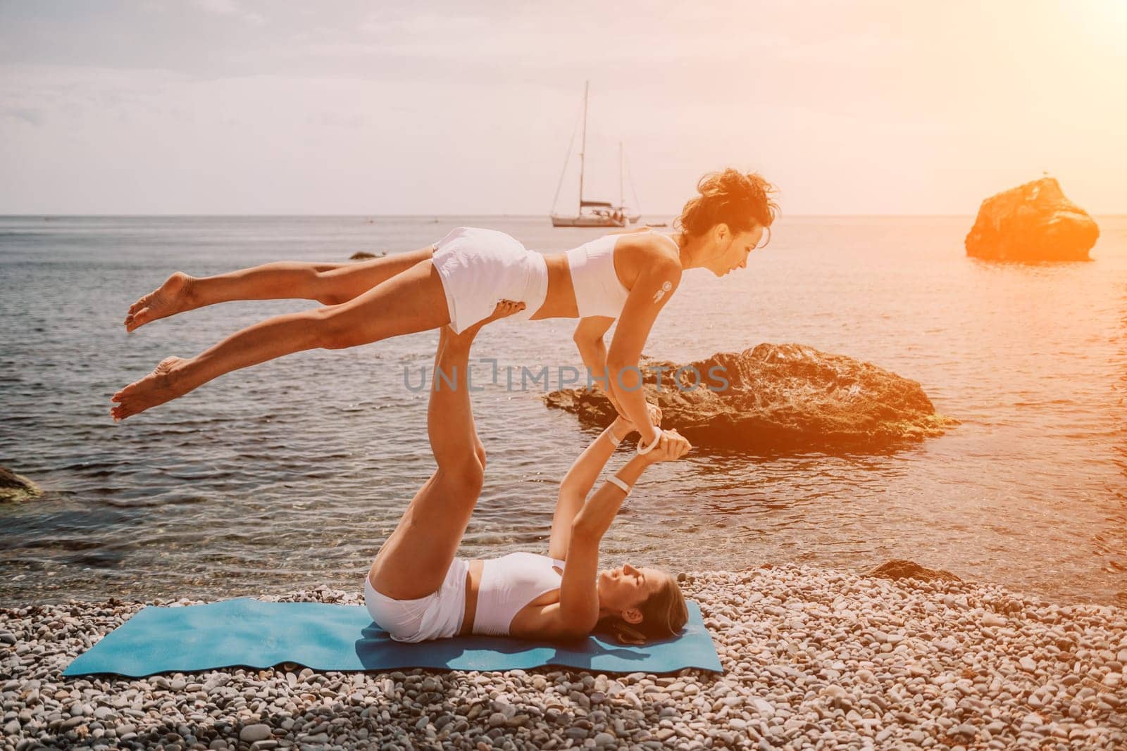 Woman sea yoga. Back view of free calm happy satisfied woman with long hair standing on top rock with yoga position against of sky by the sea. Healthy lifestyle outdoors in nature, fitness concept.