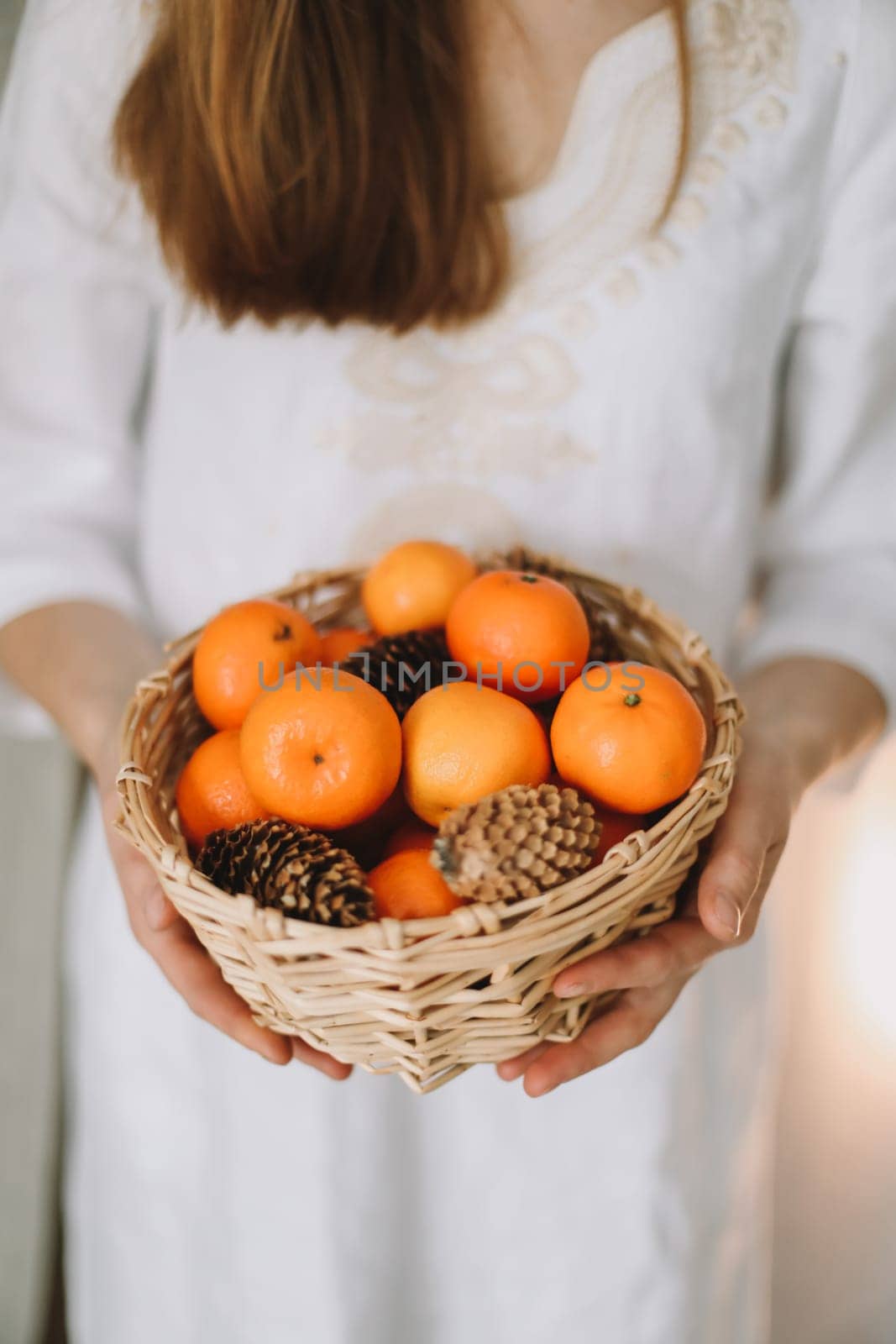 Woman holding basket with fresh tangerines. New Year and Christmas concept by paralisart