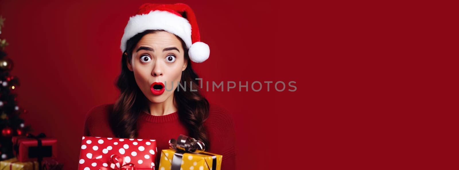 Surprised girl in Santa Claus hat holding gift box. Christmas holidays. Boxing Day shopping. Holiday shopping.