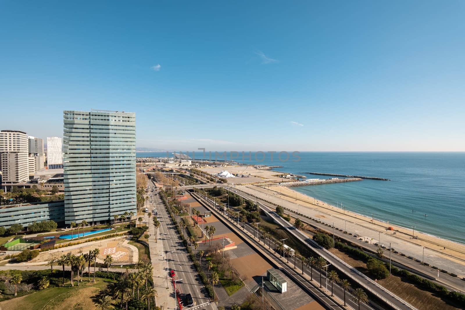 Sea waterfront in Diagonal Mar area in Barcelona with skyscrapers. Coastline area of city with highway and urban beaches. Place of dreams