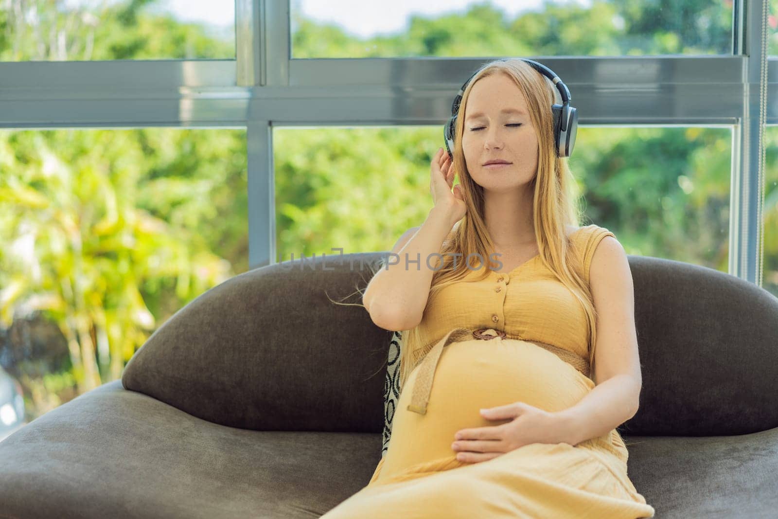 Expectant mom finds joy in her pregnancy, listening to soothing music for a serene and harmonious connection with her unborn baby by galitskaya