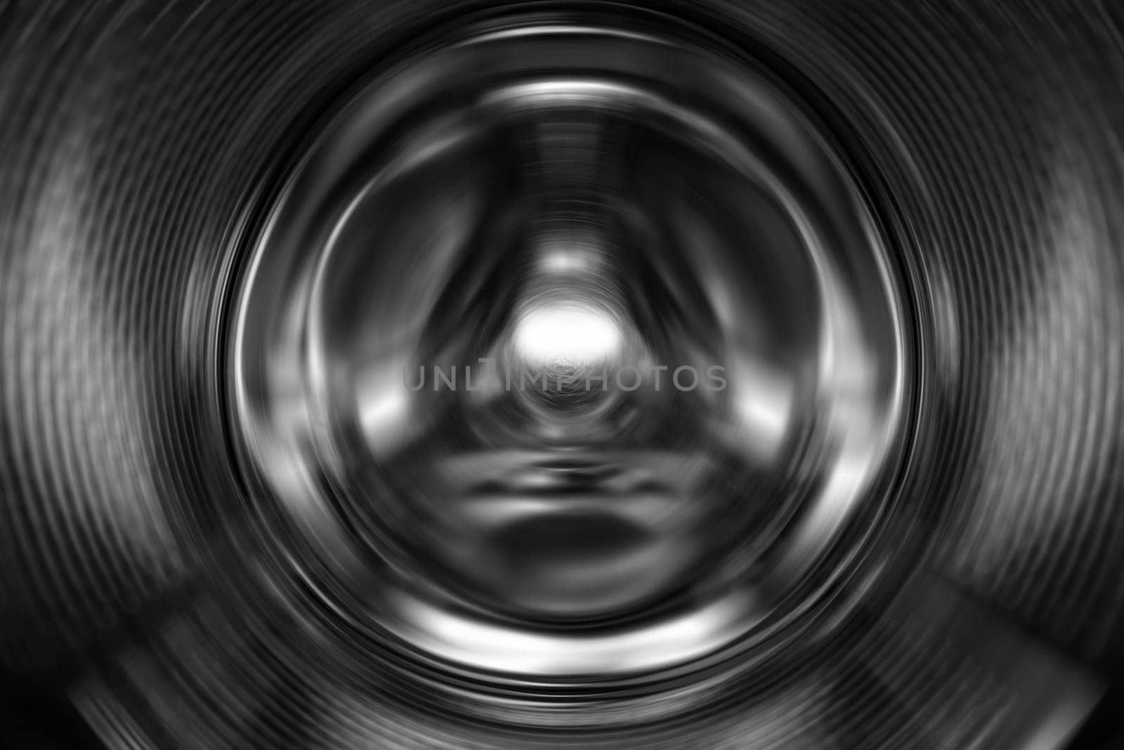 Washing Dryer Machine inside view during work. Drum of the washing machine rotates, view from the inside. Metal drum of a washing machine. Abstract home background. Inside of washing machine by EvgeniyQW