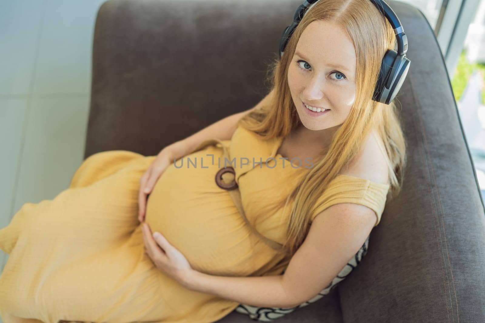 Expectant mom finds joy in her pregnancy, listening to soothing music for a serene and harmonious connection with her unborn baby by galitskaya