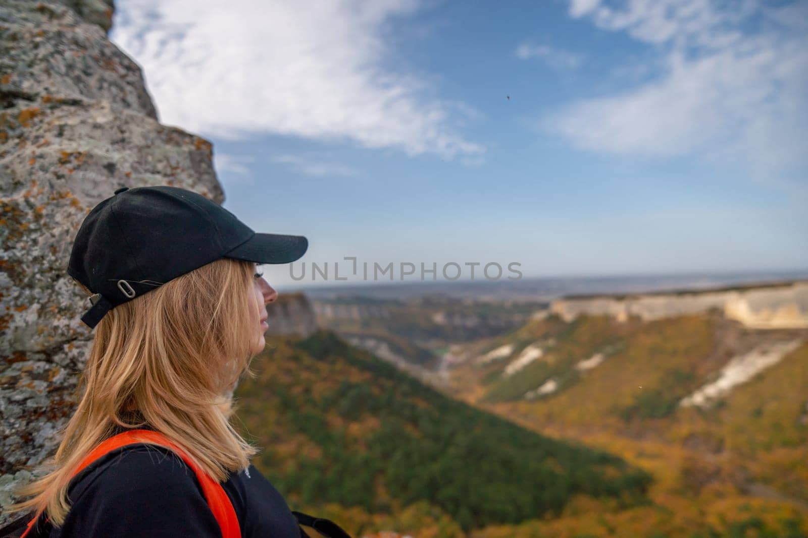 woman backpack on mountain peak looking in beautiful mountain valley in autumn. Landscape with sporty young woman, blu sky in fall. Hiking. Nature by Matiunina