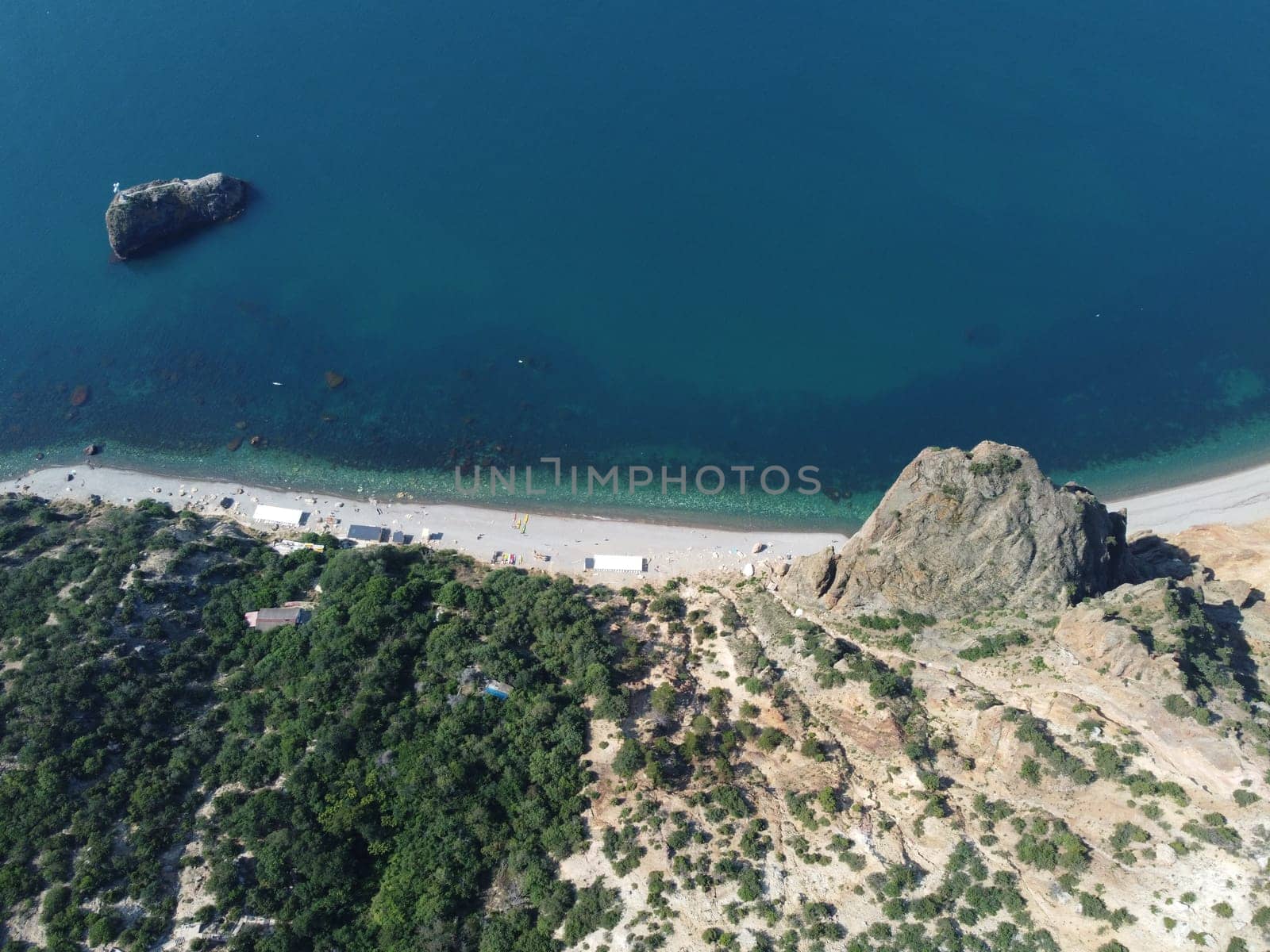 Aerial view from above on calm azure sea and volcanic rocky shores. Small waves on water surface in motion blur. Nature summer ocean sea beach background. Nobody. Holiday, vacation and travel concept by panophotograph