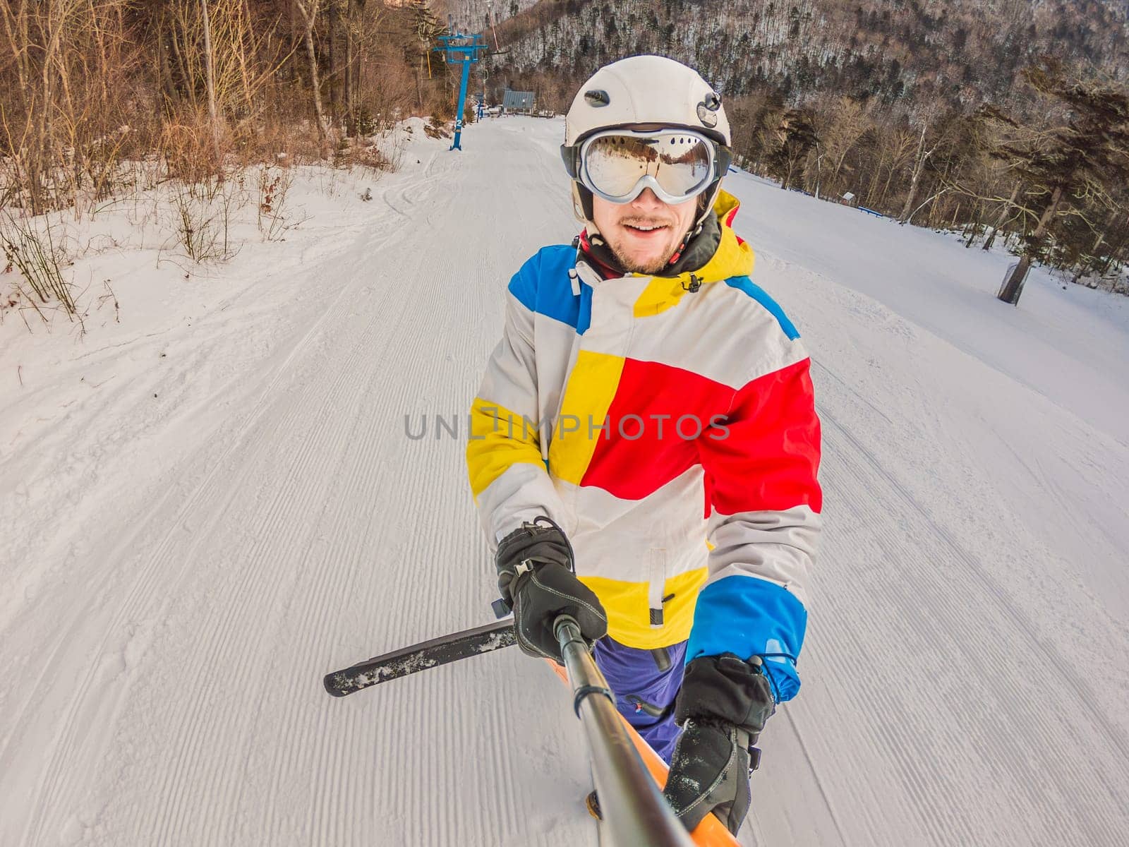 A daring man conquers snowy slopes with style, showcasing skill and thrill as he maneuvers on a snowboard, capturing the essence of winter adventure by galitskaya