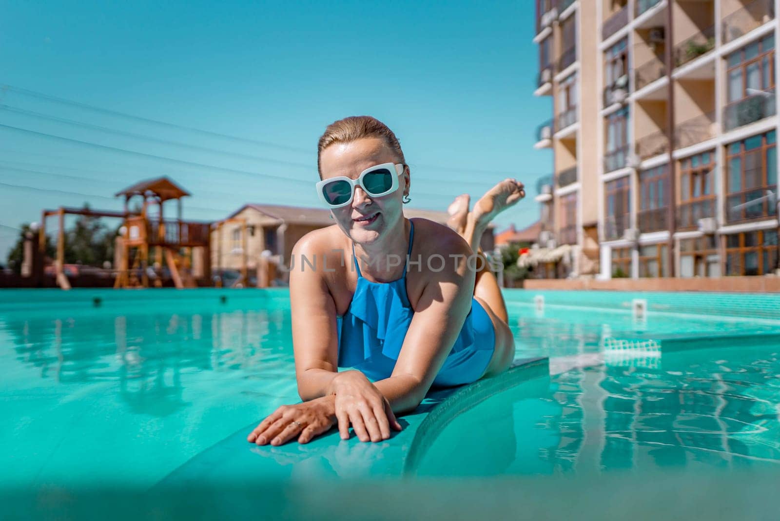 Bikini-clad woman enjoys poolside relaxation. Poolside ambiance. Capturing woman's relaxed time near pool. by Matiunina