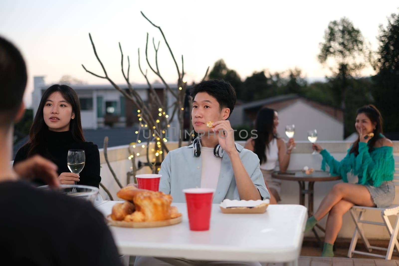 Group of young friends laughing and having fun at rooftop party