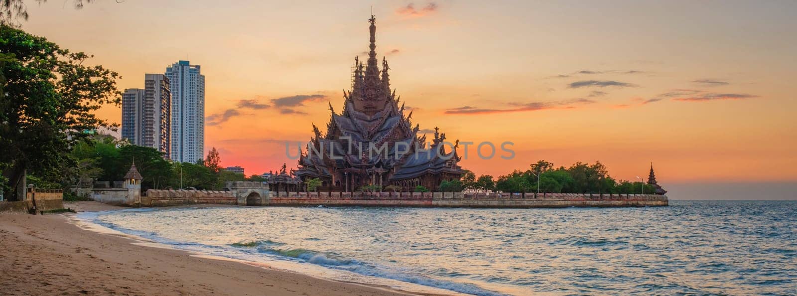 The Sanctuary of Truth wooden temple in Pattaya Thailand at sunset by the ocean beach of Pattaya