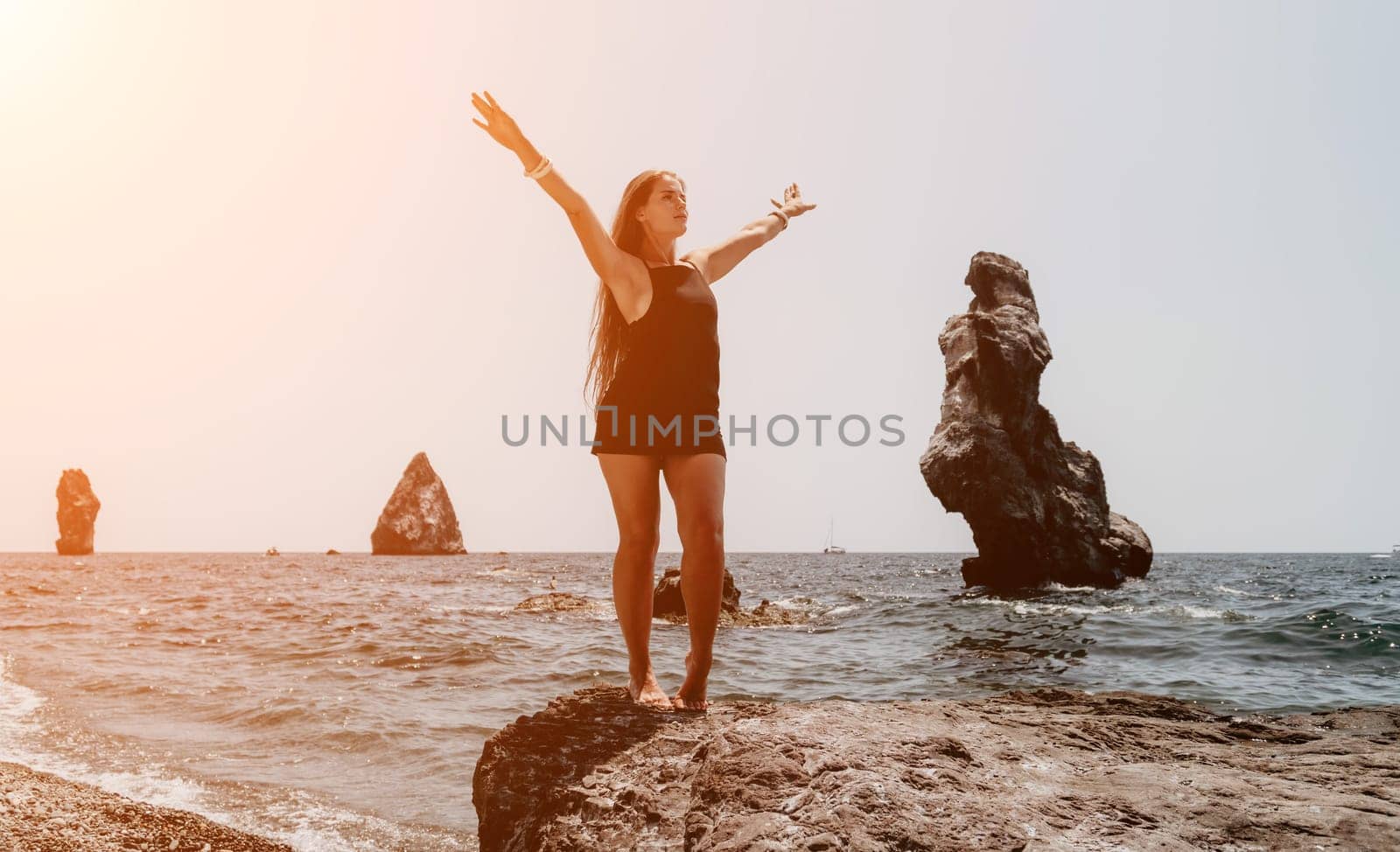 Woman summer travel sea. Happy tourist in hat enjoy taking picture outdoors for memories. Woman traveler posing on the beach at sea surrounded by volcanic mountains, sharing travel adventure journey by panophotograph