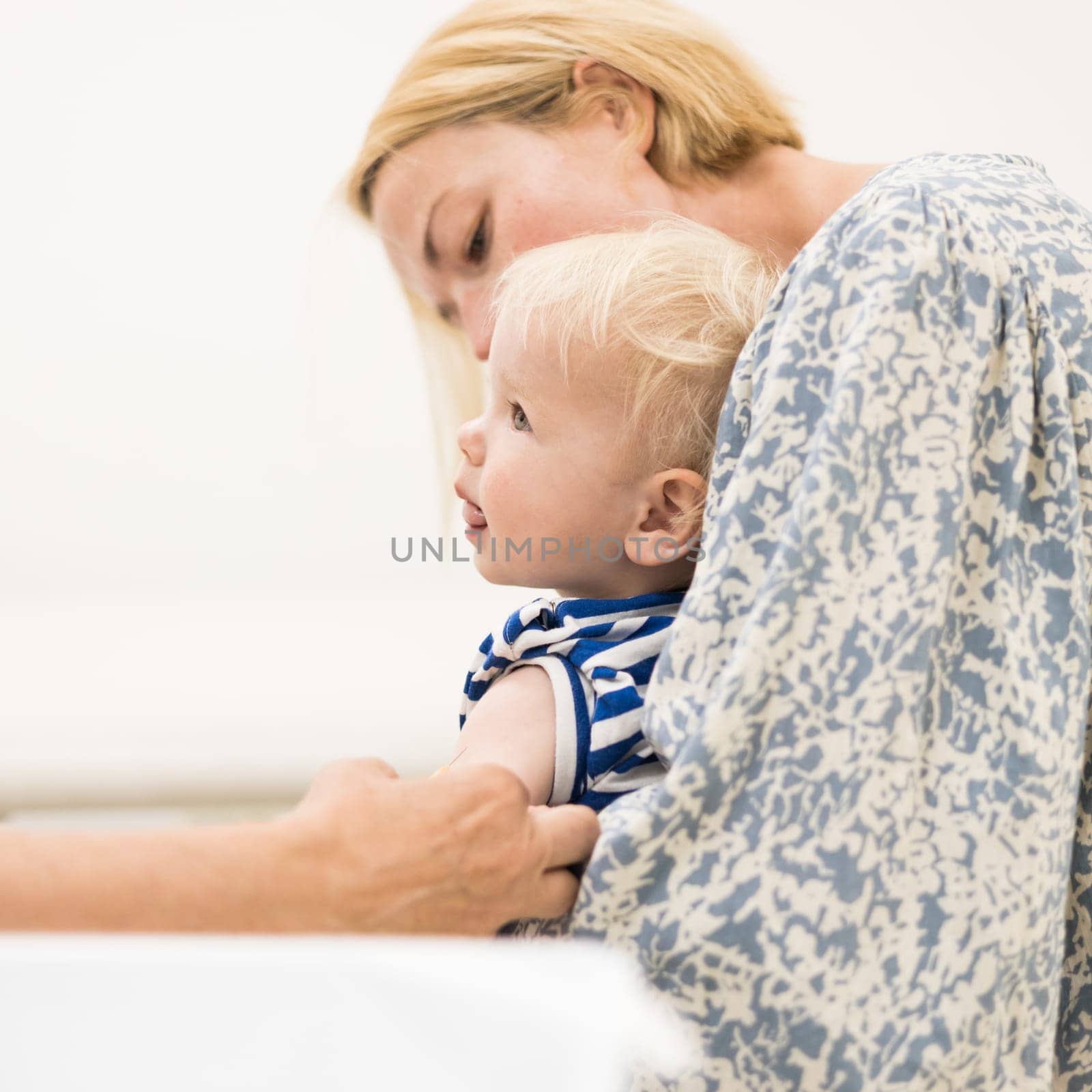 child beeing vaccinated by pediatrician in presence of his mother. Preventive vaccination against Diphtheria, whooping cough, tetanus, hepatitis, haemophilus influenzae, pneumococcus, poliomyelitis.