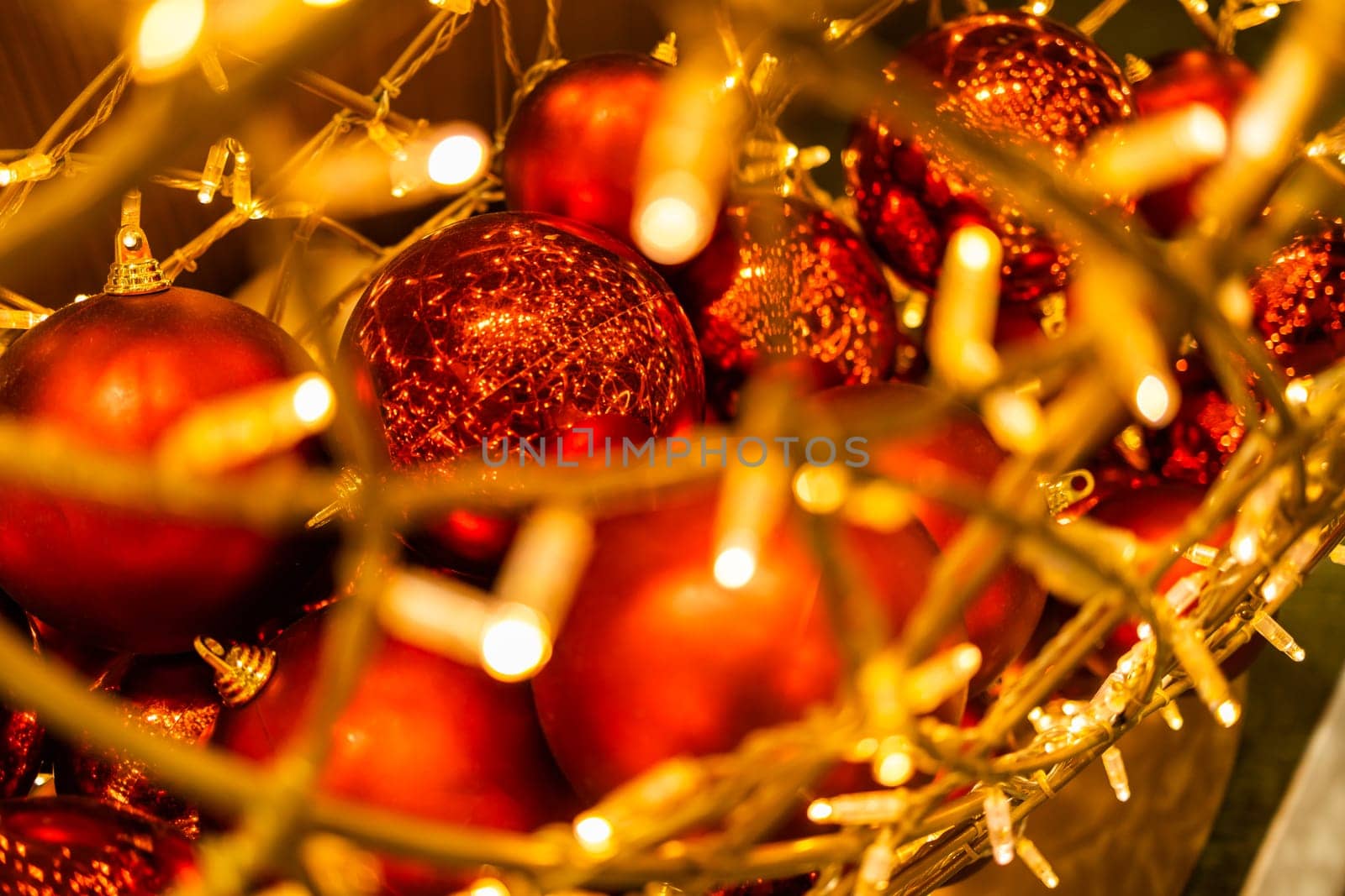 Red glowing Christmas balls garlands close-up. Holidays decoration and festive xmas concept. Copy space and empty place for text, mock up greeting card.