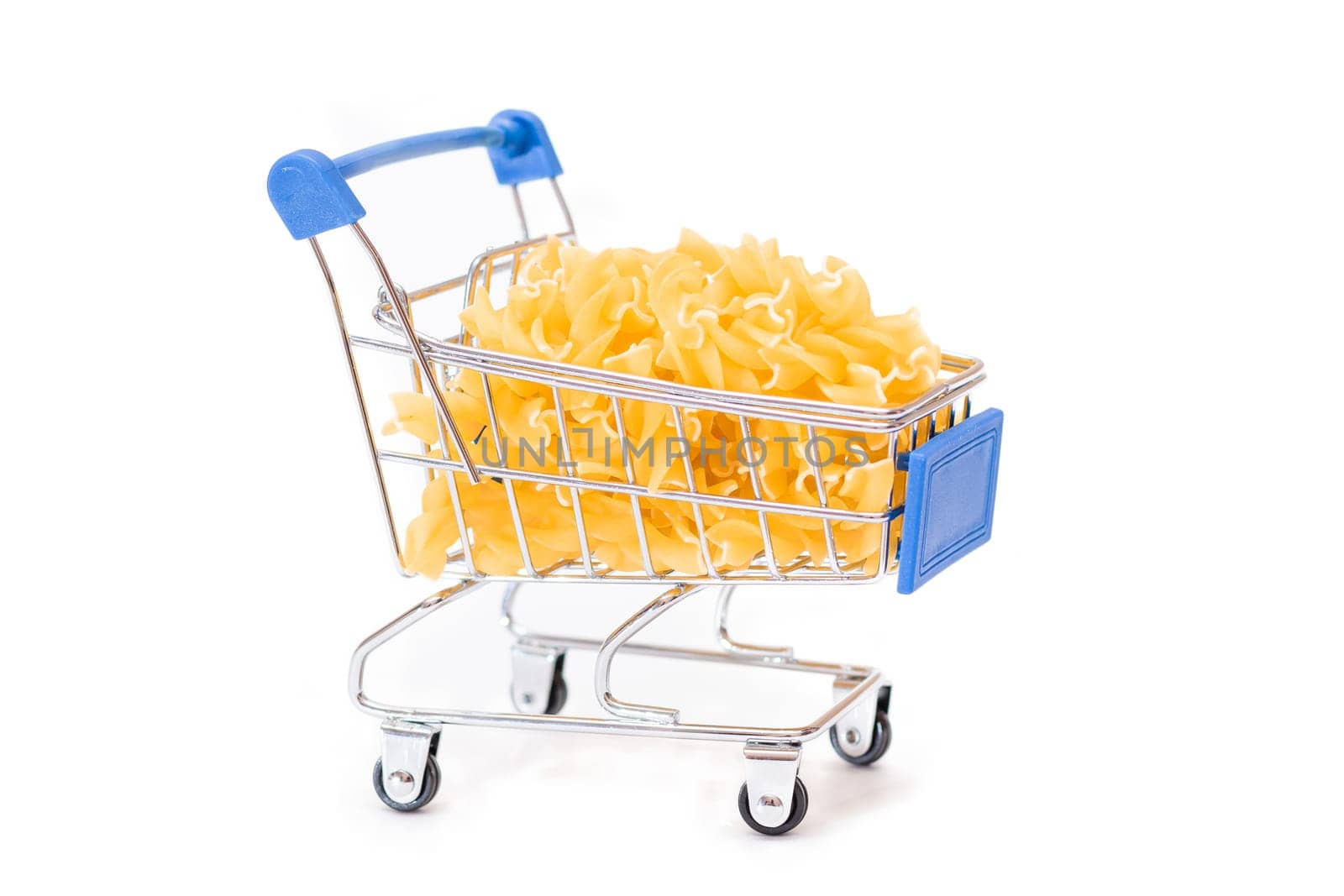 Uncooked Fusilli Pasta in Small Shopping Cart Isolated on White Background. A Crisis: Buying Cheap Food. Classic Dry Spiral Macaroni. Italian Culture and Cuisine. Raw Pasta - Isolation