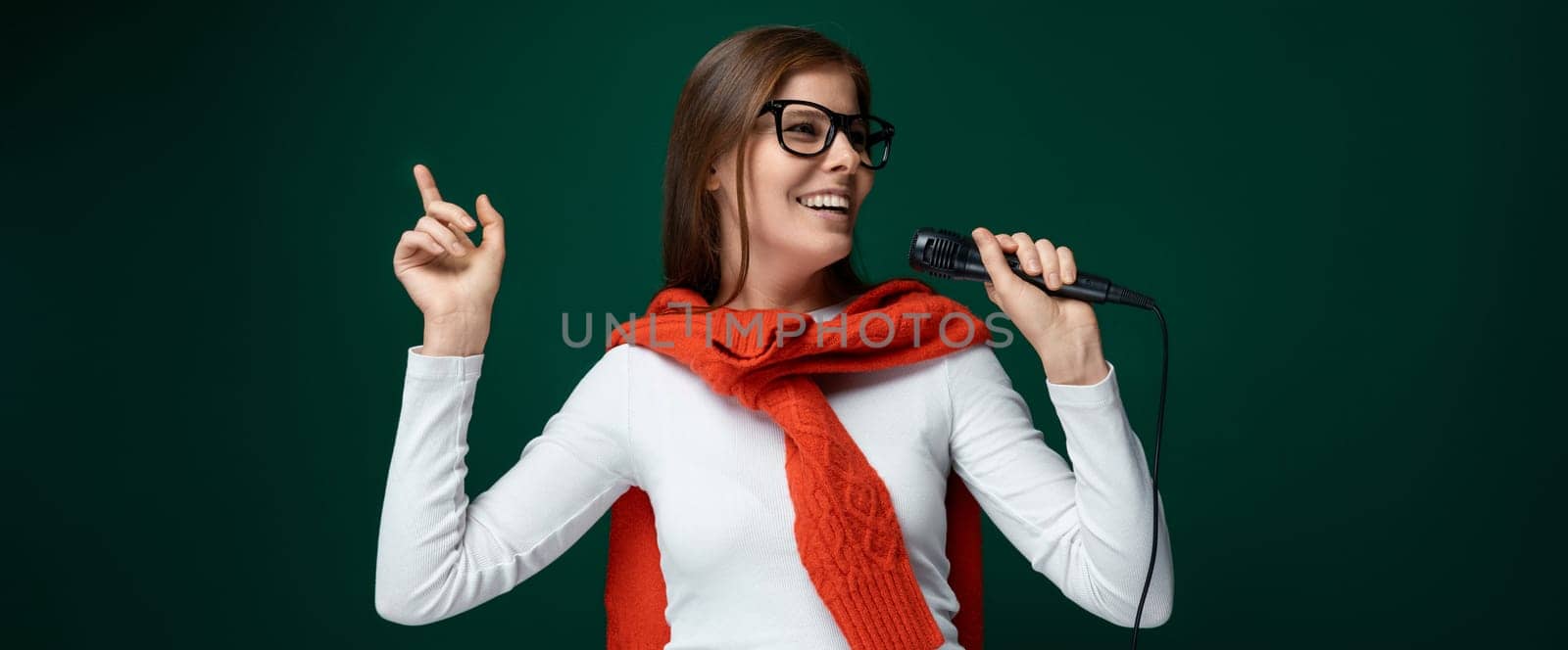 Young woman singer holding a microphone and singing a song by TRMK