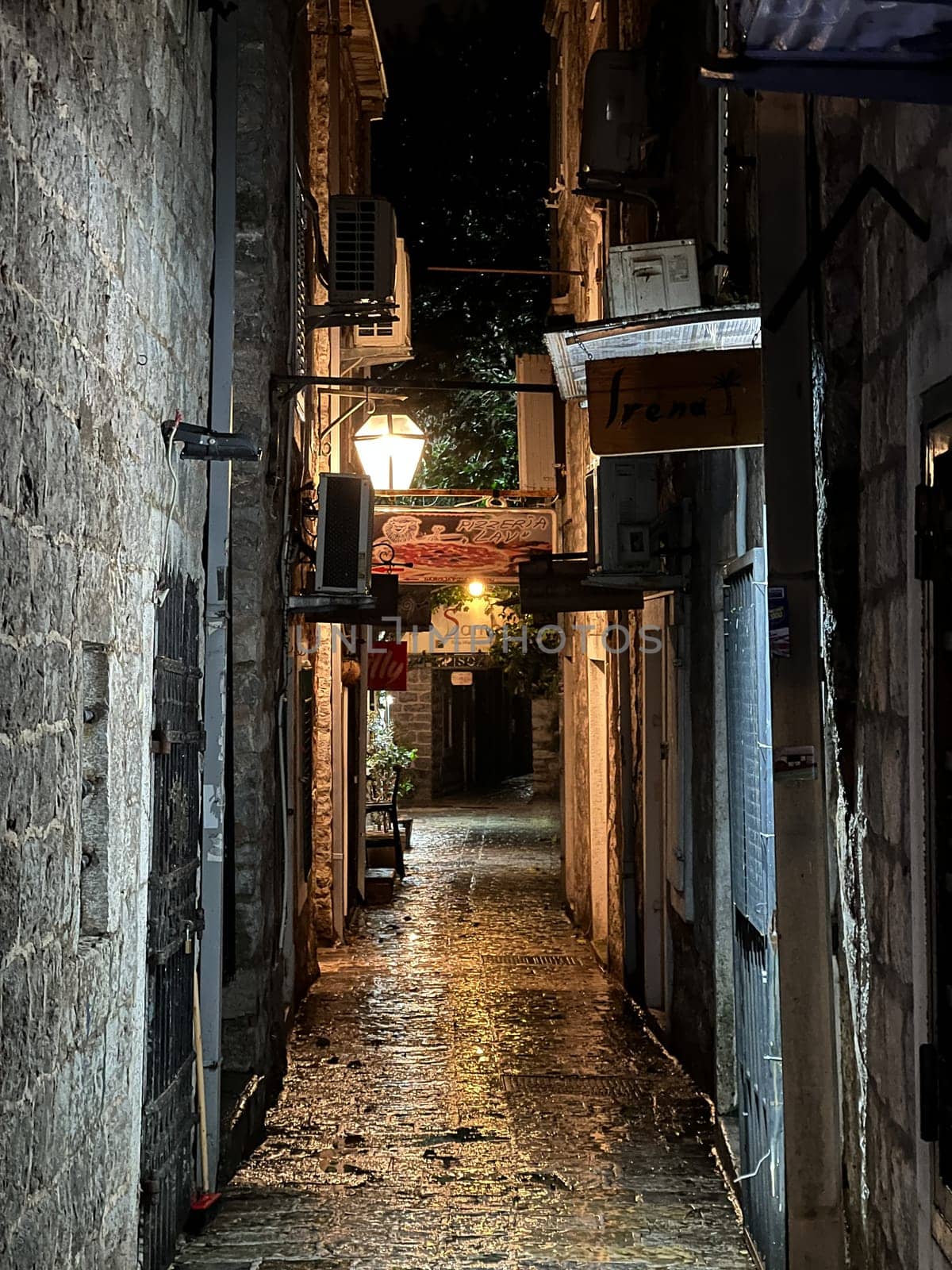 Narrow ancient street with stone houses illuminated by a lantern. High quality photo