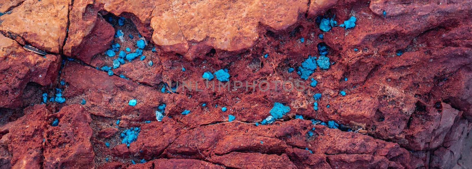 Red rock with scattering background photo. Close-up blue scattered in the stone. Texture in nature for wallpaper. High quality picture for wallpaper