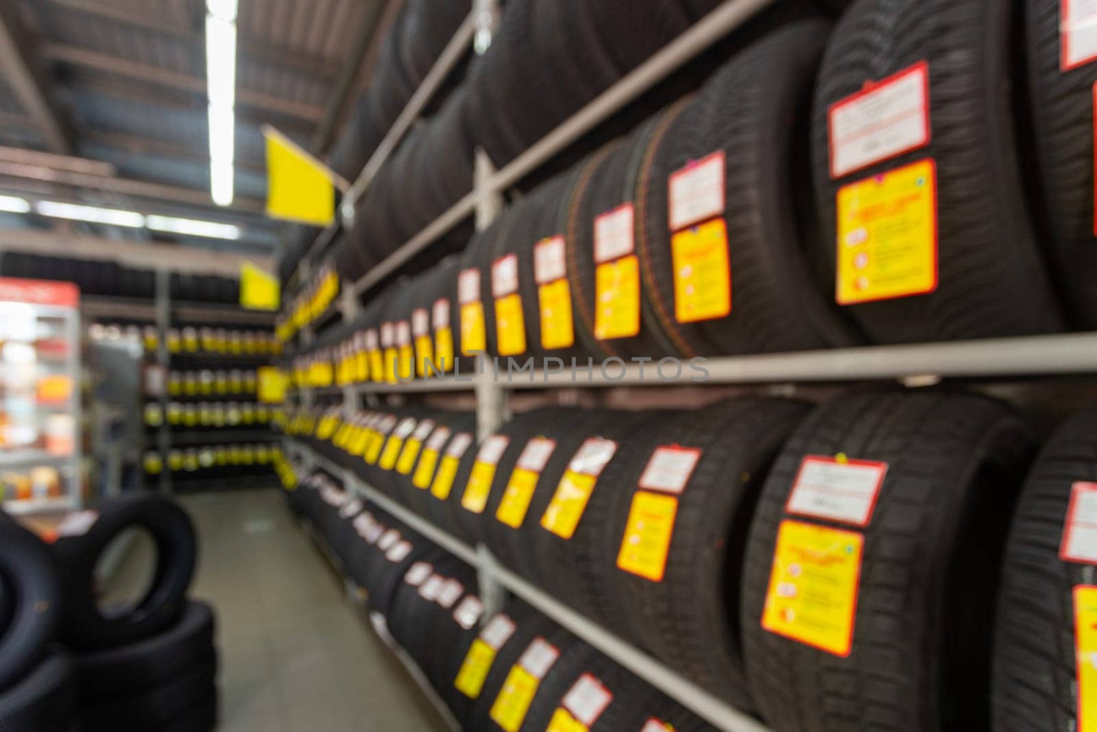 Blurred image rows of brand new tires for sale at retail store. Defocused background interior of auto and tire trading store. Transportation services concept. Vintage tone.