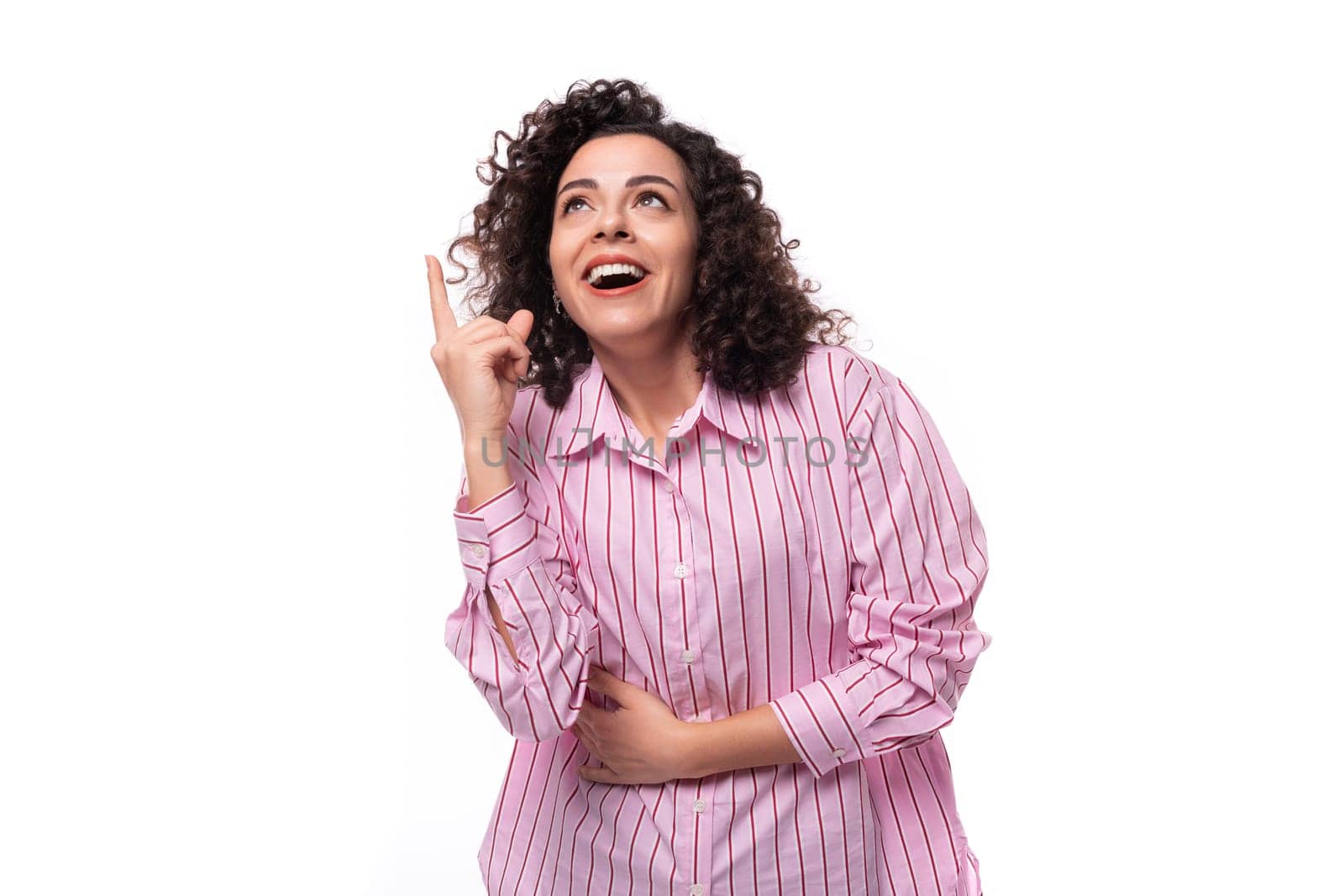 young confident brunette curly businesswoman dressed in a striped pink shirt by TRMK