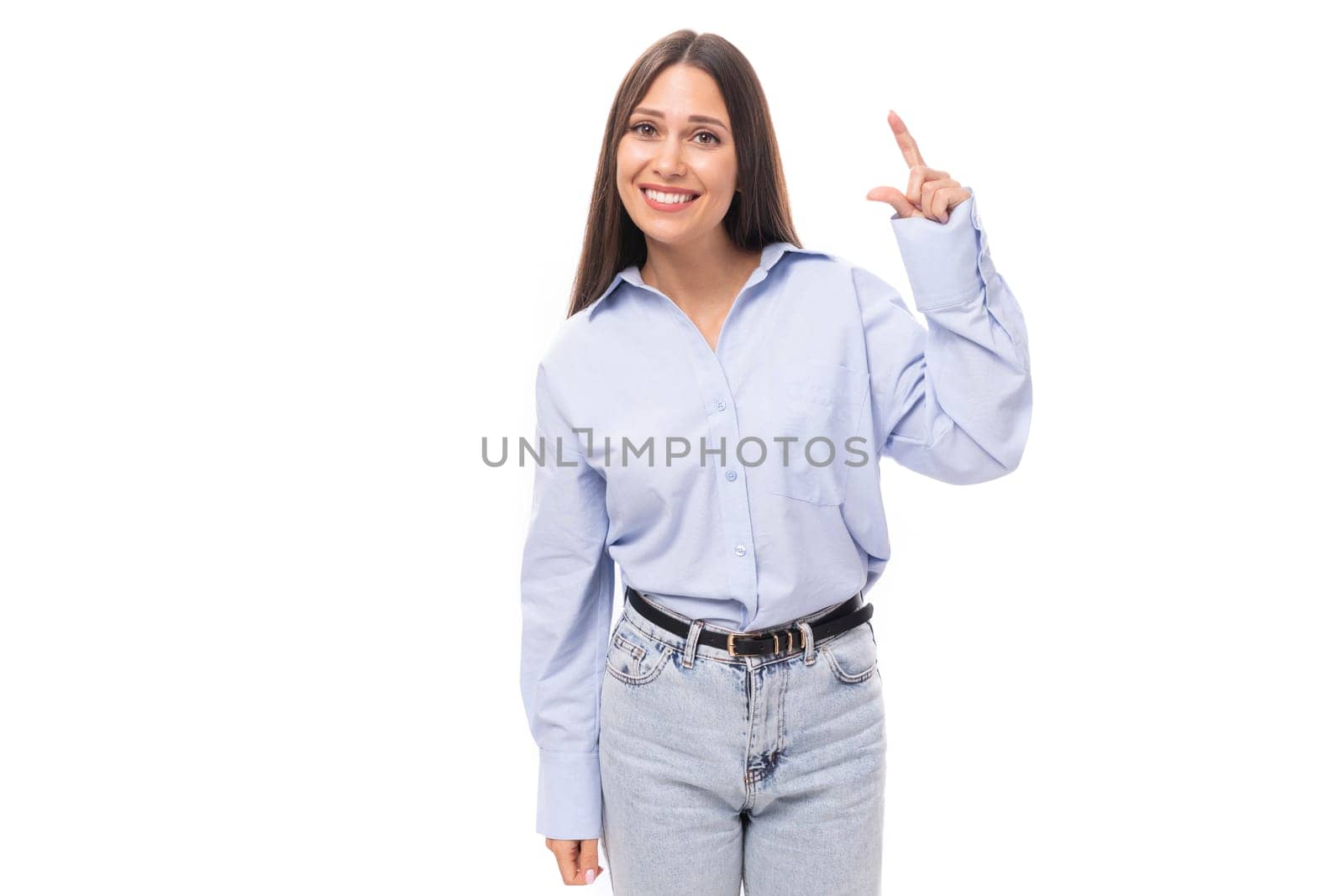 young beautiful european brunette business woman with light makeup in a light blue shirt on a white background with copy space.