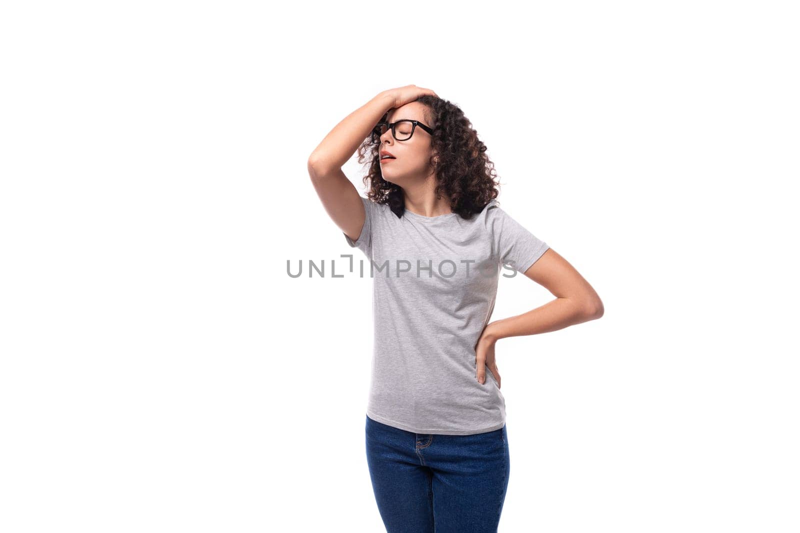 dreamy caucasian young brunette woman with shoulder-length curly hair on a white background with copy space.