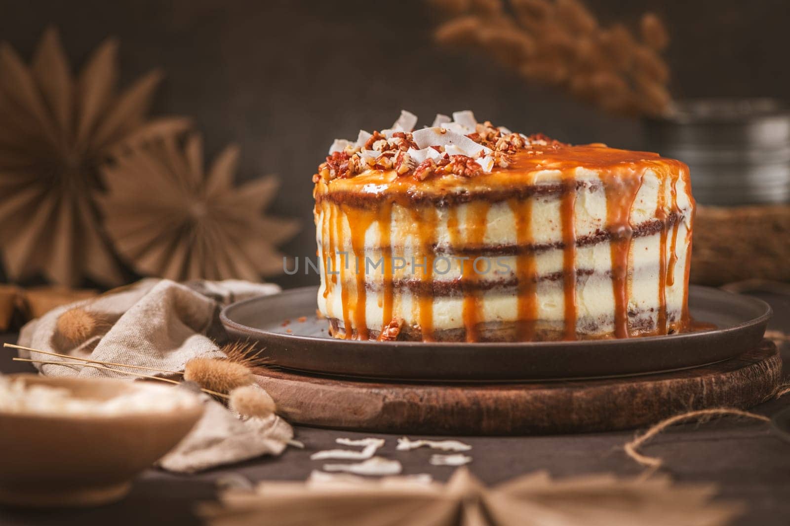 Delicious caramel cake with small pieces of pecan nuts and coconut shavings.