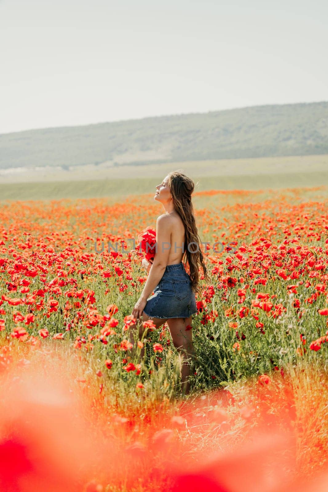 Woman poppies field. portrait happy woman with long hair in a poppy field and enjoying the beauty of nature in a warm summer day. by Matiunina