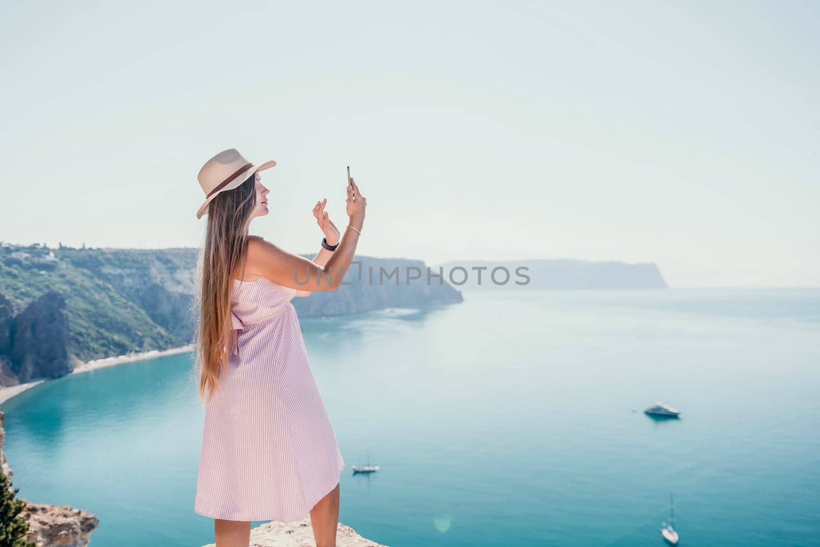 Woman sea laptop. Business woman in yellow hat freelancer with laptop working over blue sea beach. Girl relieves stress from work. Freelance, digital nomad, travel and holidays concept by panophotograph